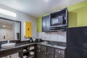 A modern kitchen with a microwave, sink, and stove.