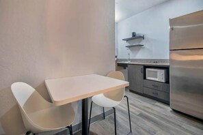 Una cocina moderna con un refrigerador de acero inoxidable, un microondas y una pequeña encimera.