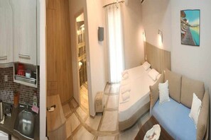 A bedroom with a bed, a bedside table, a nightstand, a window with curtains, and a painting on the wall. - Nidri Zone (Lefkada)