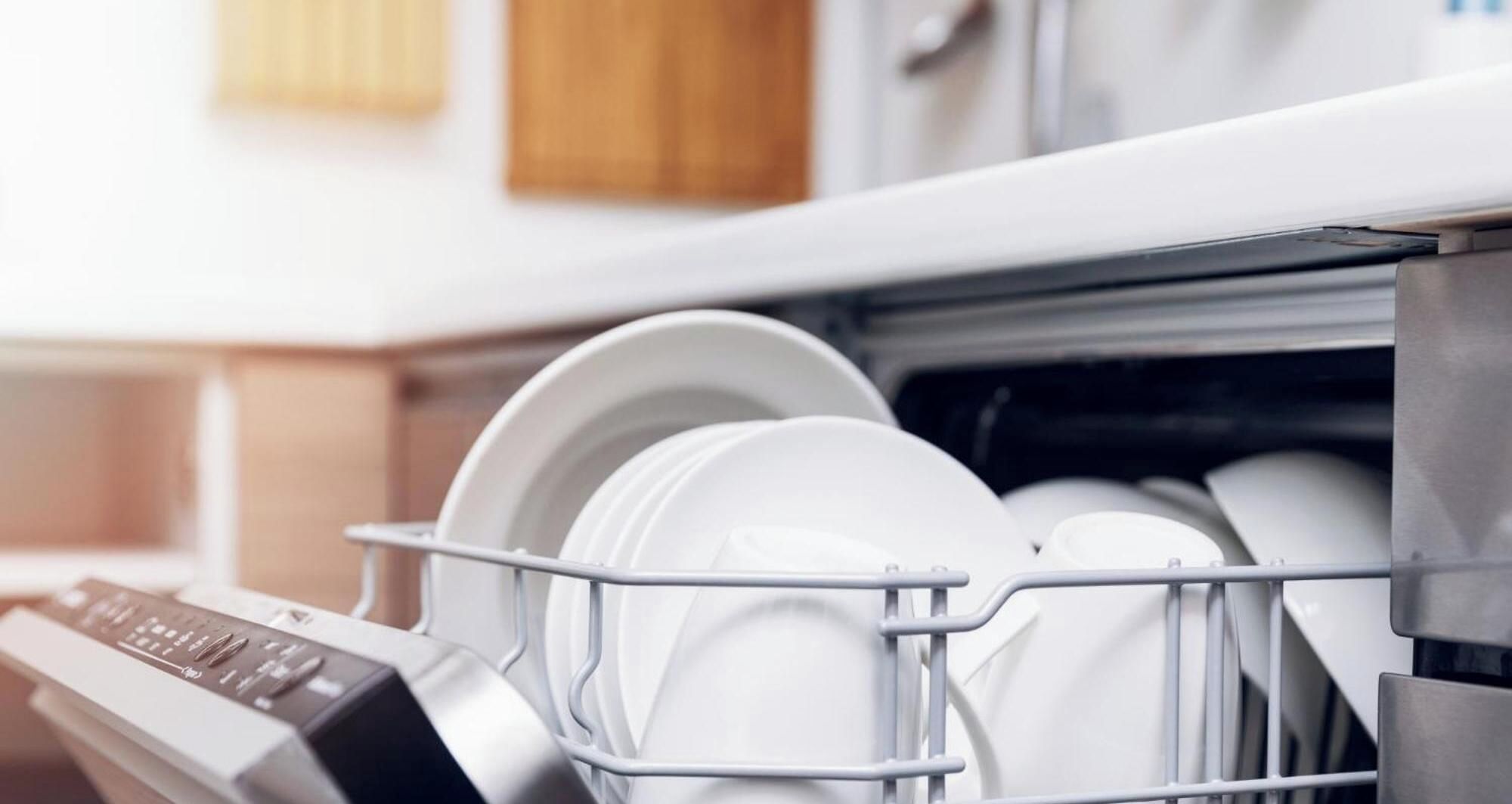 A dishwasher with white plates and bowls inside.