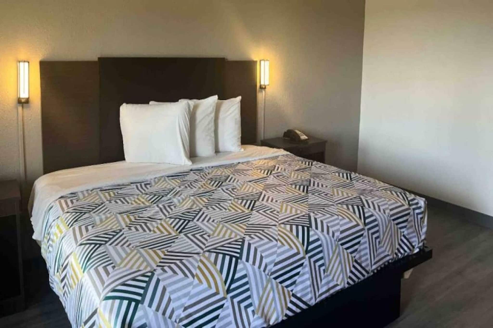Une chambre d’hôtel avec un lit, deux lampes de chevet et une table de chevet.