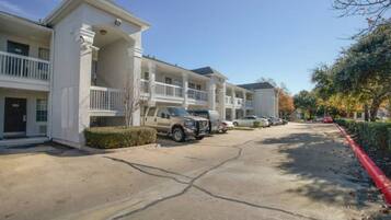 A multi-story residential building with a parking area in front.