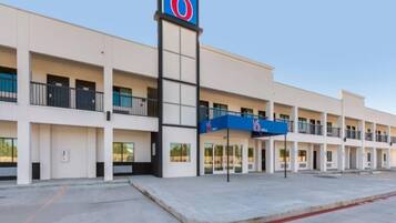 A 6-story motel with a central entrance and multiple balconies.