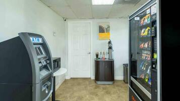 Una habitación con cajero automático, máquina expendedora, puerta y armario.