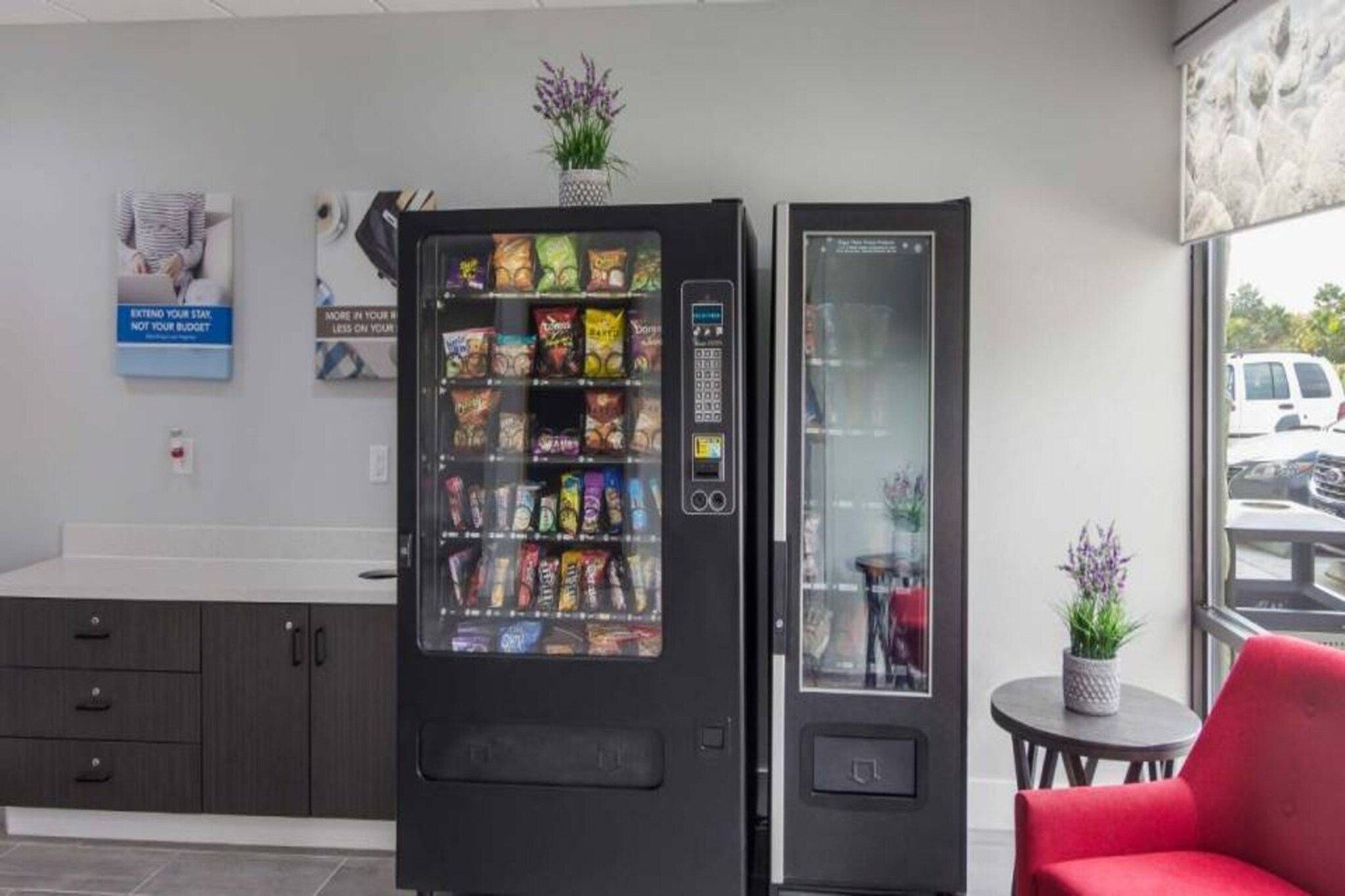 A vending machine with snacks and a glass display unit in a modern interior.