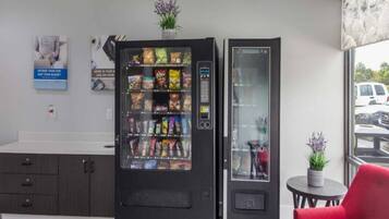 A vending machine with snacks and a glass display unit in a modern interior.