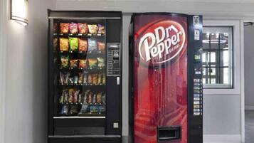 A vending machine with a variety of snacks and a Dr Pepper dispenser.