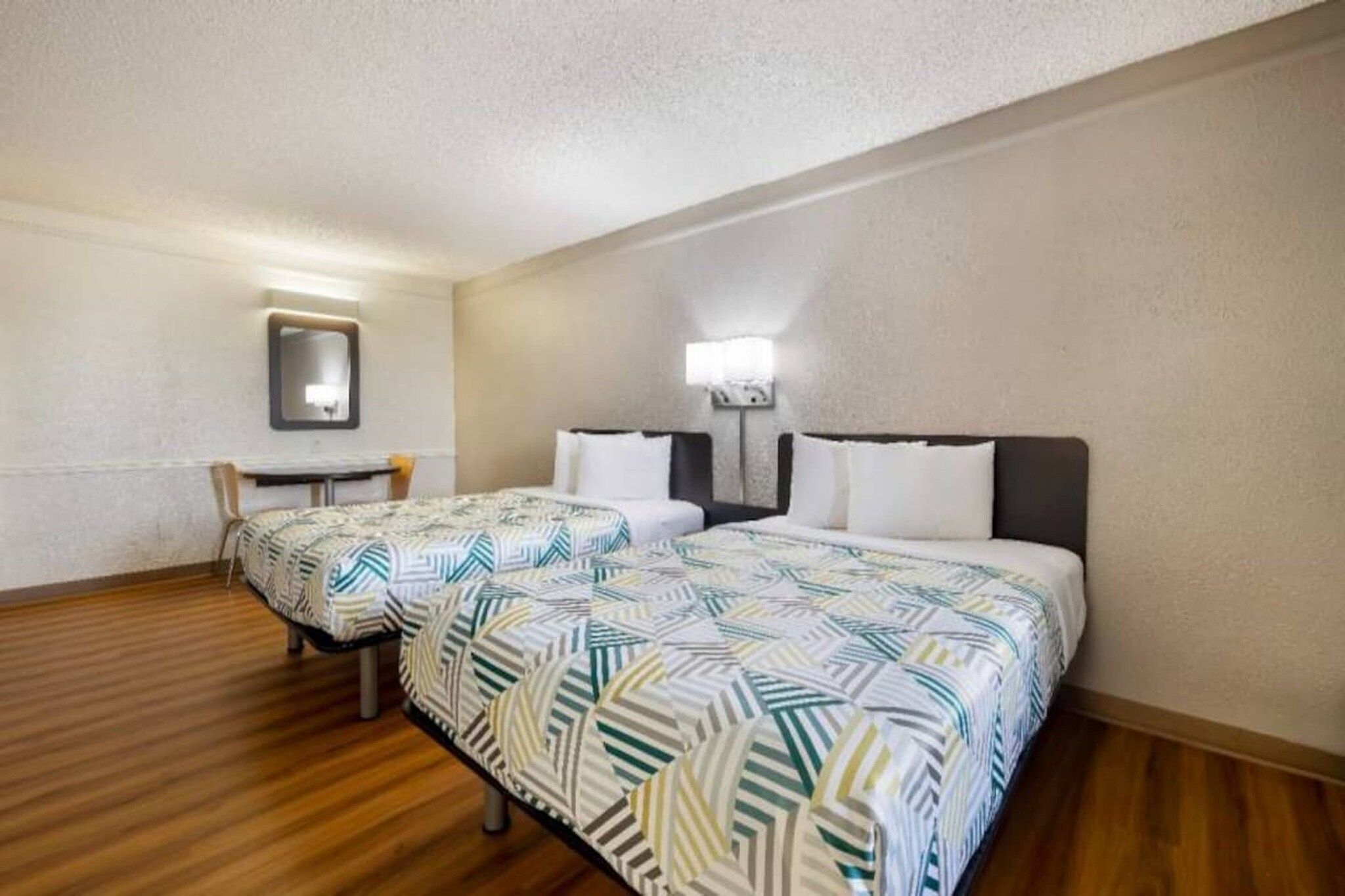 Une chambre d’hôtel avec un lit, un bureau et une chaise.