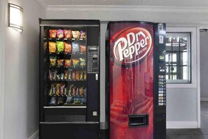 Un distributeur automatique proposant une variété de collations et un distributeur de Dr Pepper.