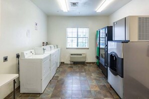 A laundry room with a washing machine, dryer, and stacked dryers. - 1 King Bed | Non-Smoking, Micfridge (Winnie)
