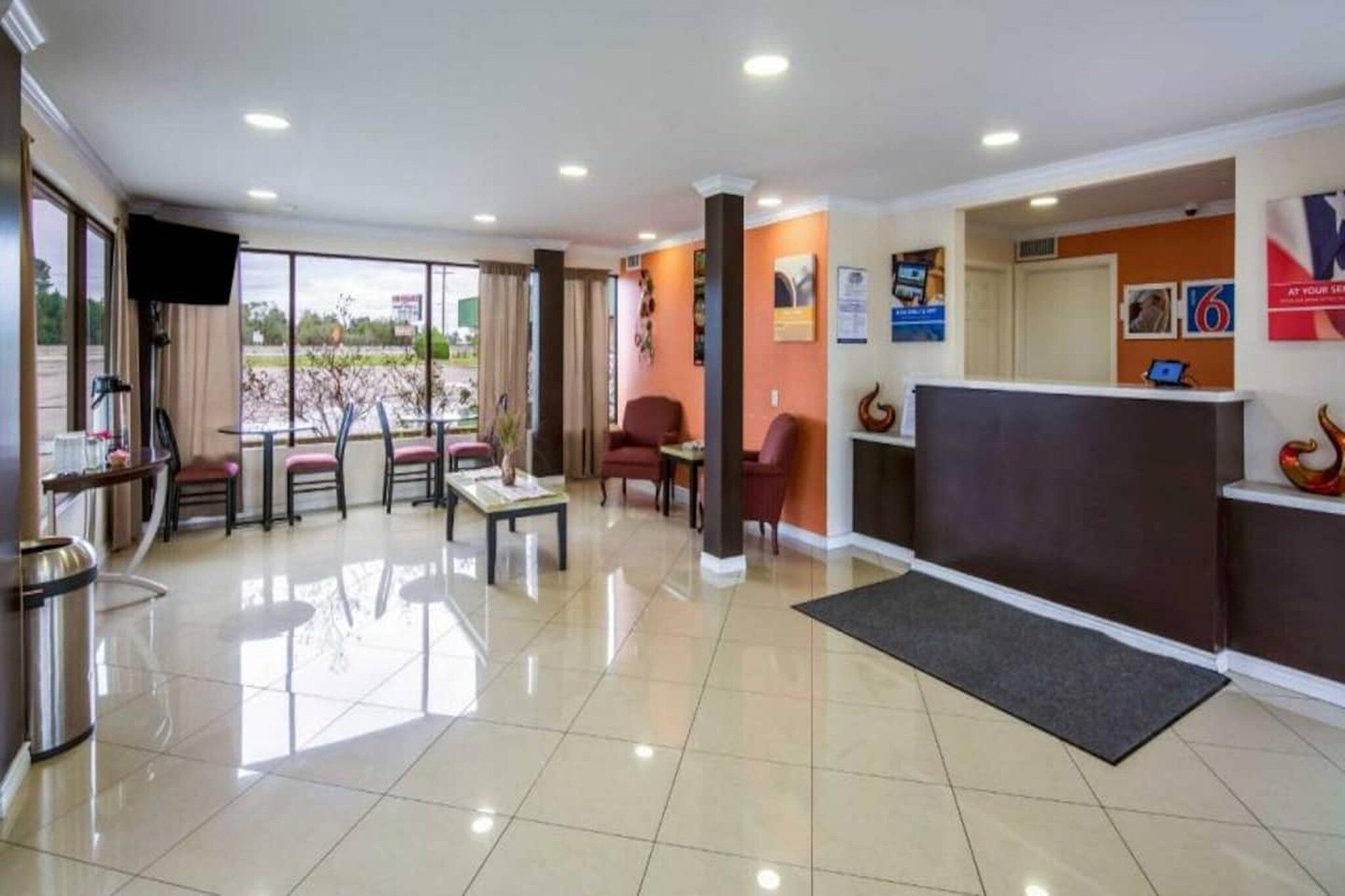Vestíbulo de hotel con recepción, zona de estar y vistas al exterior.