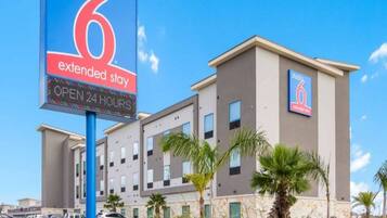 A hotel with a sign indicating extended stay availability and 24-hour operation.