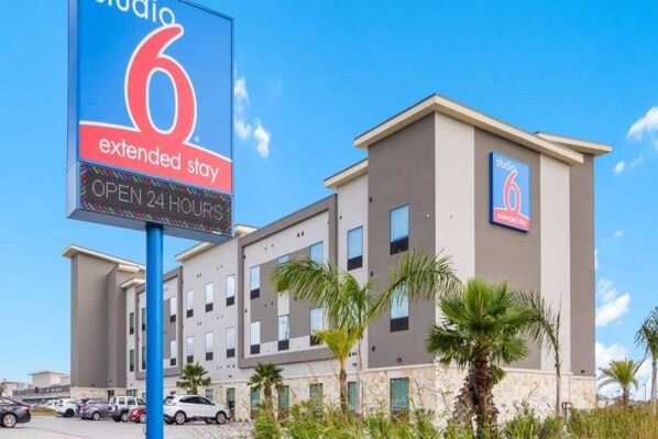 Ein Hotel mit Schild, das Langzeitaufenthalte und einen 24-Stunden-Betrieb anzeigt.