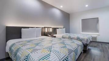 A modern hotel room with a large bed, two bedside tables, and a window with blinds.