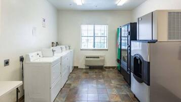 A laundry room with a washing machine, dryer, and stacked dryers.