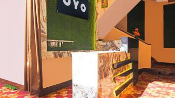A reception desk with a sign that reads 'OYO' and a small statue on top.
