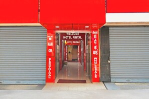 Un edificio rojo y blanco con un letrero que dice 'WELCOME HOTEL PRIYAL'.