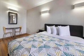 Ein Hotelzimmer mit Bett, Schreibtisch und Stuhl.
