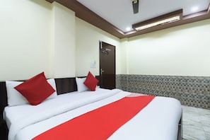 Una camera d'albergo con un letto, una porta e un muro rivestito di piastrelle.