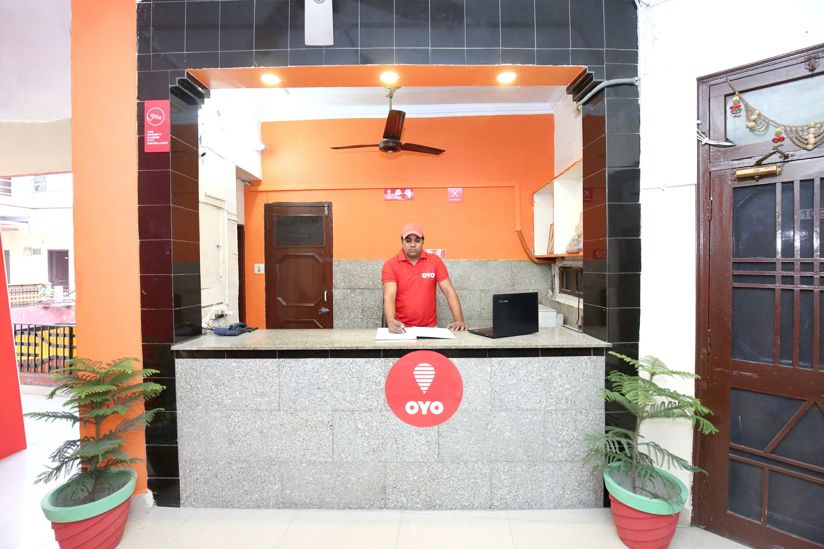 A reception desk with a logo, a ceiling fan, and a door.
