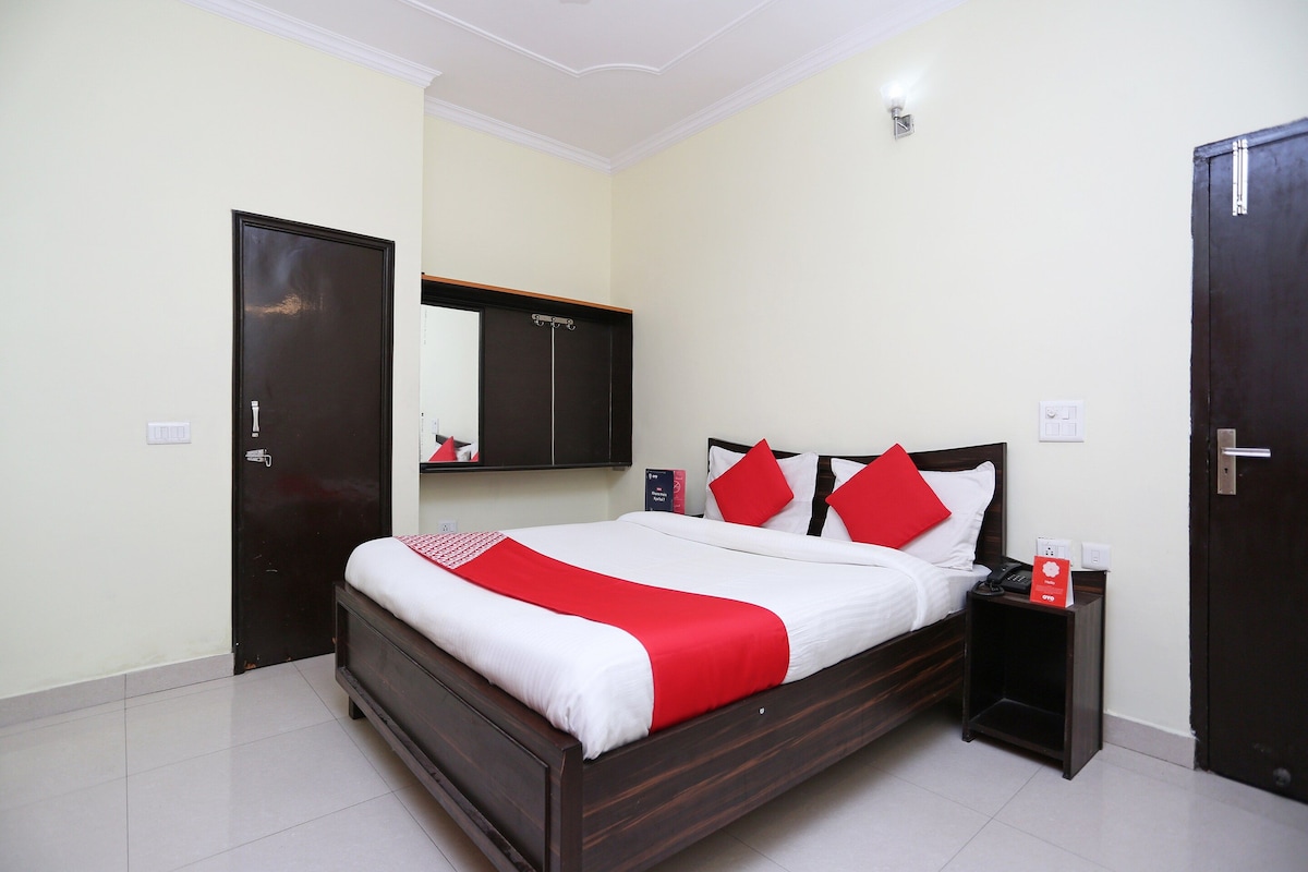A hotel room with a bed, a nightstand, a wardrobe, and a mirror.