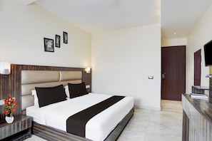 A hotel room with a bed, bedside table, and a TV on a stand. - Collection O Railway Station Dehradun (Dehradun)