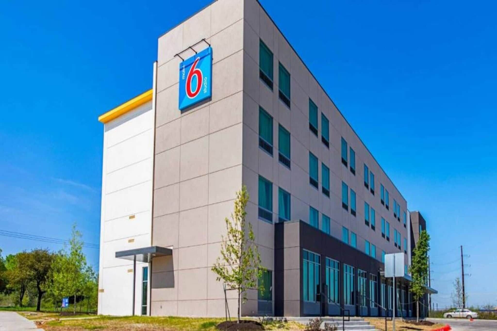 A modern building with a prominent '6' sign, multiple windows, and a flat roof.