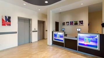 A reception area with two reception desks, a hallway, and a door.