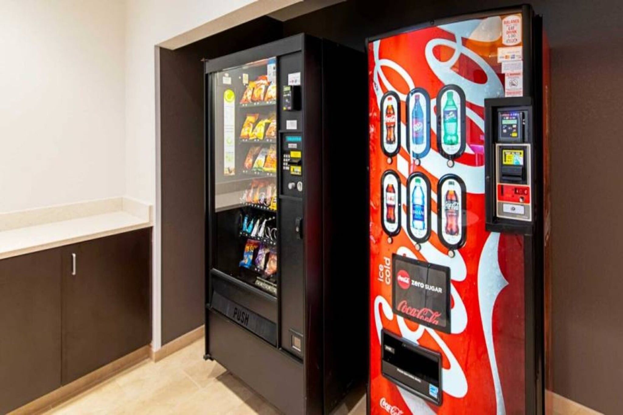 A vending machine with a Coca-Cola logo and a push button interface.