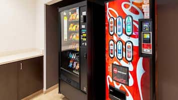 A vending machine with a Coca-Cola logo and a push button interface.