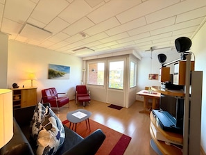 A living room with a sofa, chairs, a table, a lamp, and a television. - Holiday Apartment With 2 Bedrooms (Wyk auf Foehr)