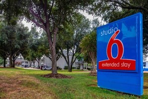 A sign for Studio 6 Extended Stay with a blue background and red text. - 1 Queen Bed | Smoking, Micfridge (Arlington)