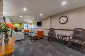 A hotel lobby with seating areas, a clock on the wall, and a television mounted above a table. - 2 Full Beds | Non-Smoking, Kitchen (Plano)