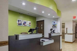 A reception desk with a computer, a telephone, and a chair. There are three framed pictures on the wall above the desk. - 1 King Bed|Mobil Access Tub NS Kitchen (Plano)