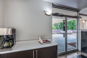 Habitació d'hotel amb una cafetera, una caixa de mocadors i vista al carrer.