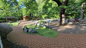 A landscaped garden with a brick pathway, rock formations, and a wooden structure. - Brüggemann Bummelallee Vacation Rental (Bad Harzburg)