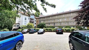 A parking area with multiple cars and a building with a modern facade. - Brüggemann Bummelallee Vacation Rental (Bad Harzburg)