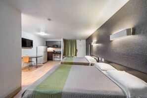 A hotel room with a bed, a desk, a chair, a microwave, and a small kitchenette. - 2 FULL BEDS | SMOKING, KITCHEN (Irving TX)