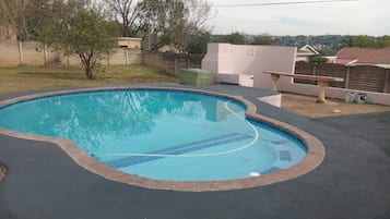 A swimming pool with a curved edge and a tiled interior.