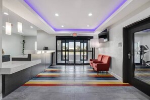 A reception area with a modern design, including a reception desk, seating area, and a glass door entrance. - 2 Queen Beds|Mobil|Tub|Micfridg (Katy)