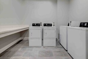 A laundry room with two stacked washers and dryers, a bench, and a tiled floor. - 2 Queen Beds|Mobil|Tub|Micfridg (Katy)