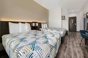 Ein Hotelzimmer mit zwei Betten, einem Schreibtisch und einem Sessel.