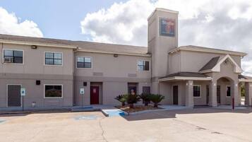 A multi-story hotel with a central tower, accessible parking, and a covered entrance.