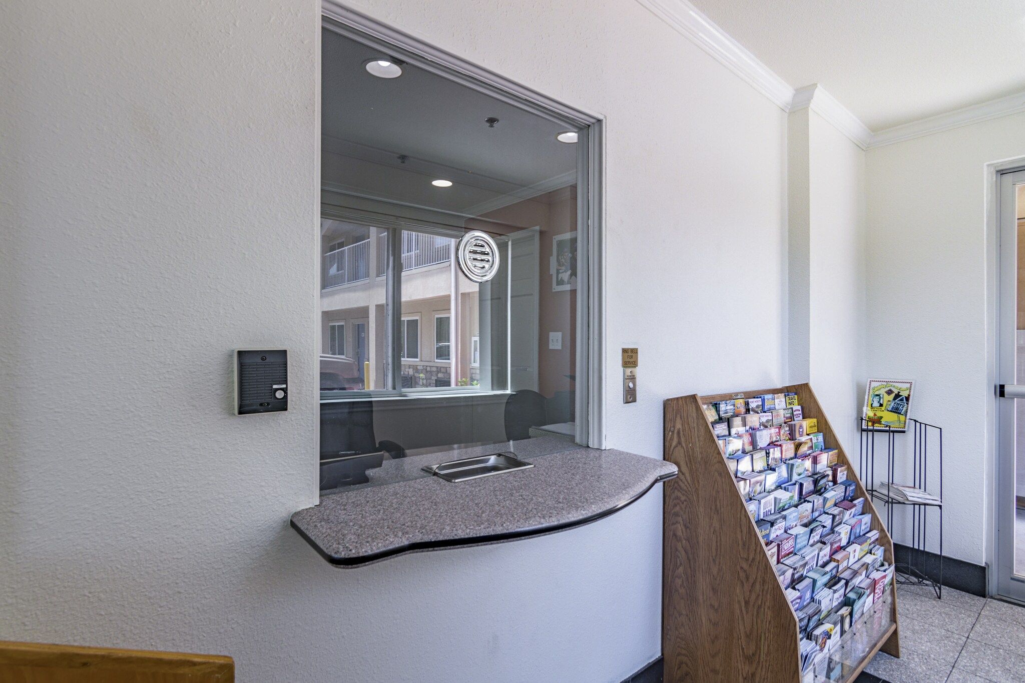 A reception area with a counter, a window, and a display of postcards.