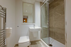 Ein Badezimmer mit Toilette, Waschbecken und einer Duschkabine.