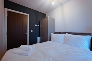 Una habitación de hotel con una cama, un armario y una puerta.
