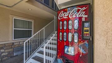 A Coca-Cola vending machine with a 'Thank You!' sign and a 'Dollar Bills' slot.