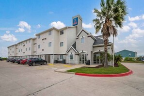 A hotel with a parking lot, a palm tree, and a clear sky. - Sunny 2 Full Beds | Nsmk, Kitchen (INGLESIDE)
