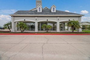 A two-story building with a flat roof, large windows, and a covered entrance area with palm trees. - Sunny 2 Full Beds | Nsmk, Kitchen (INGLESIDE)