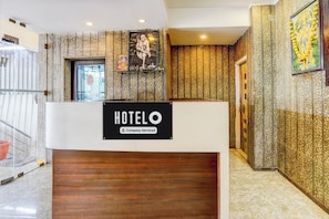 Un comptoir d’accueil d’hôtel avec un panneau indiquant qu’il est géré par l’entreprise.